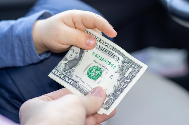 moeder die een dollar geeft aan zijn zoon vrouw en kinderen hand met een bankbiljet geld concept financi