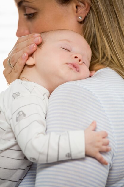 Moeder die en haar babyjongen houdt omhelst