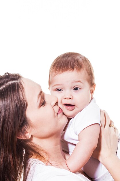 Moeder die haar baby op de witte achtergrond houdt