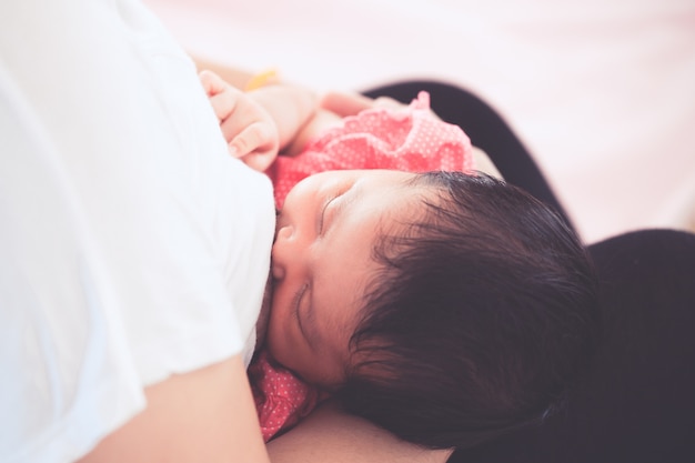 Moeder die haar pasgeboren babymeisje de borst geeft.