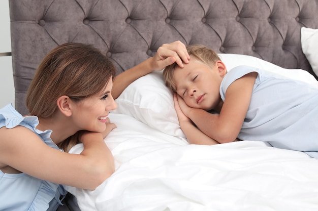 Moeder die haar zoon thuis in bed ziet slapen