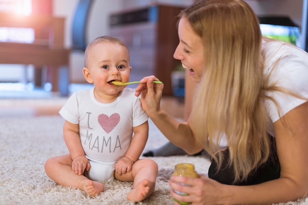 Foto moeder die haar zoontje thuis voedt