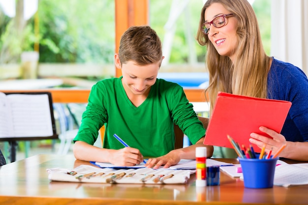 Moeder die zoon met thuiswerkopdracht helpt