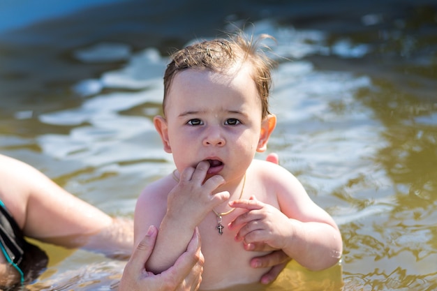 Foto moeder die zuigelingsbaby leert om in waterpool te zwemmen. waterpark. zomervakantie activiteiten