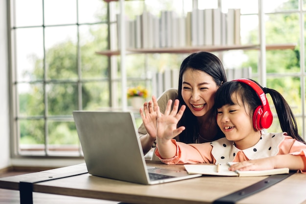 Moeder en aziatische jongen meisje leren en kijken naar laptopcomputer maken huiswerk studeren kennis met online onderwijs e-learning systeem