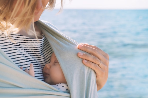 Moeder en baby buiten in de natuur baby in draagdoek vrouw met klein kind in draagdoek