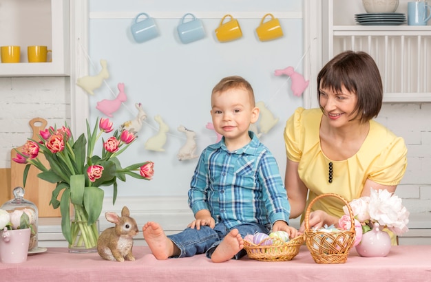 Foto moeder en baby in de pasen ingerichte pastel keuken.