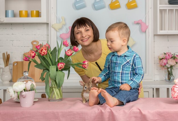 Moeder en baby in de Pasen ingerichte pastel keuken.