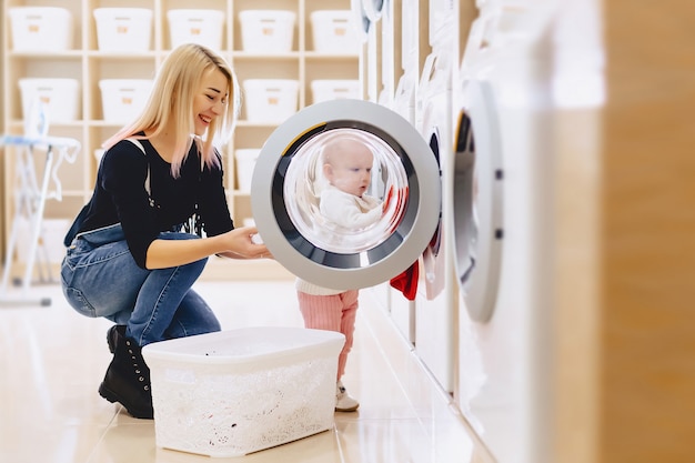 Moeder en baby in de was nemen dingen en spelen