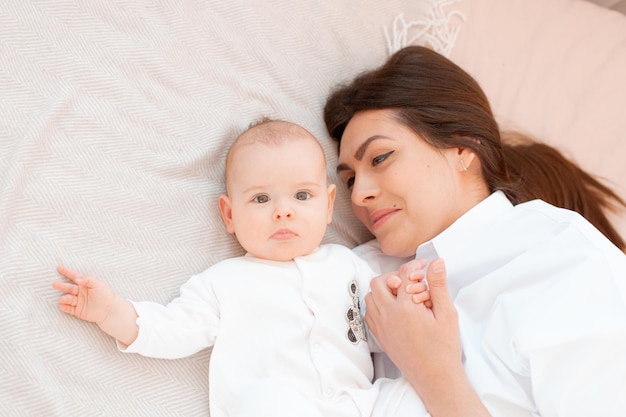 Moeder en baby liggen op het bed in de slaapkamer