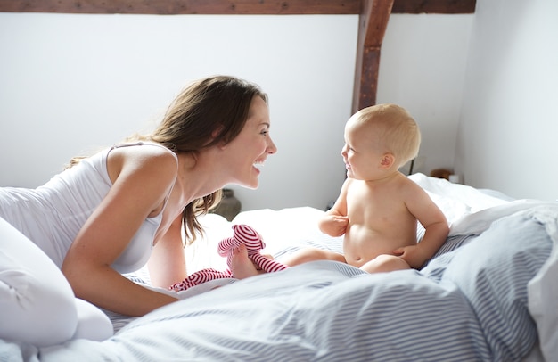 Moeder en baby spelen op bed