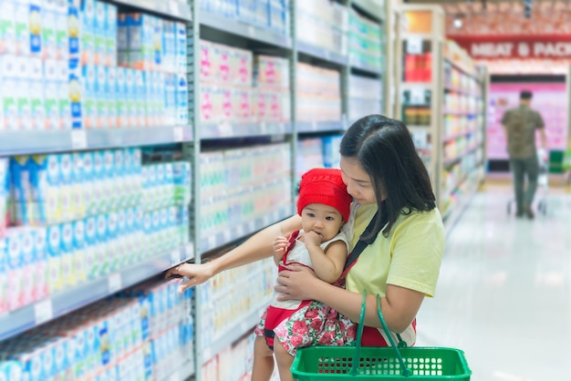 Moeder en baby winkelen in de supermarktThaise vrouw heeft een dochter