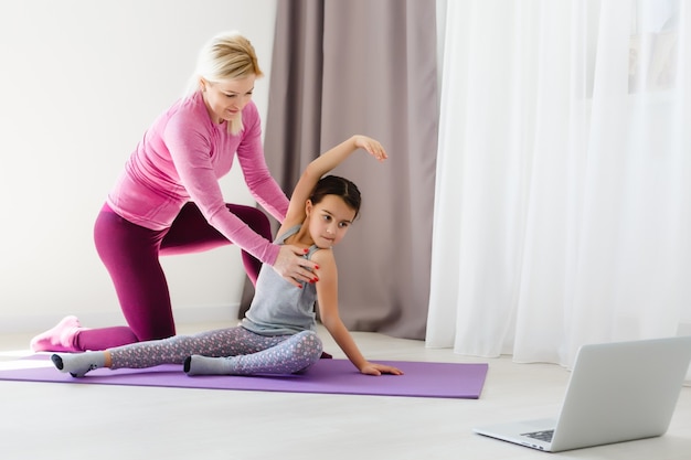 Moeder en dochter beoefenen thuis yoga