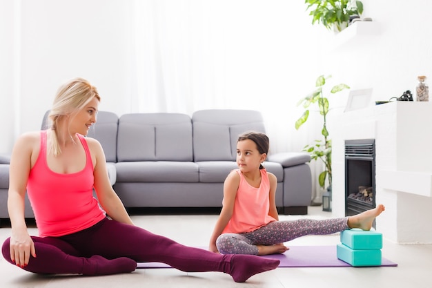 Moeder en dochter beoefenen thuis yoga