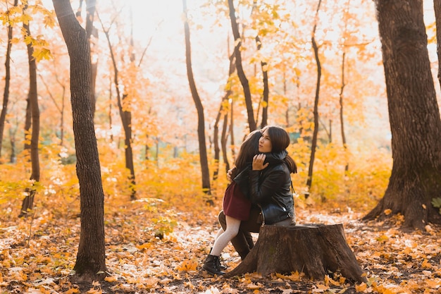 Moeder en dochter brengen samen tijd door in het herfstgeel parkseizoen en het concept voor alleenstaande ouders