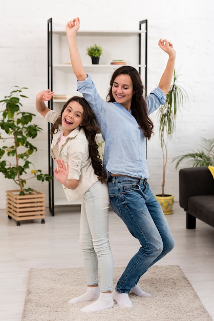 Foto moeder en dochter dansen in de woonkamer