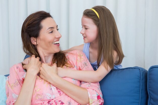 Moeder en dochter die bij elkaar glimlachen