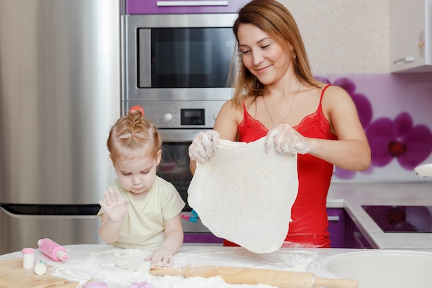 Moeder en dochter die deeg thuis keuken maken