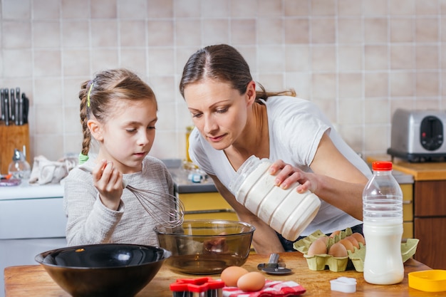 Moeder en dochter die deeg voorbereiden