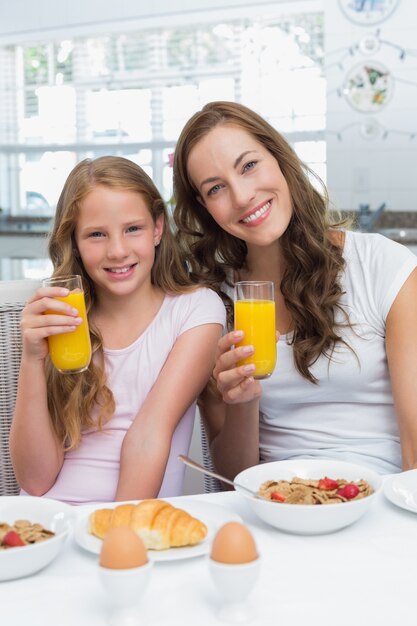 Moeder en dochter die ontbijt in keuken hebben