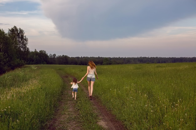 Moeder en dochter die op groen gebied lopen