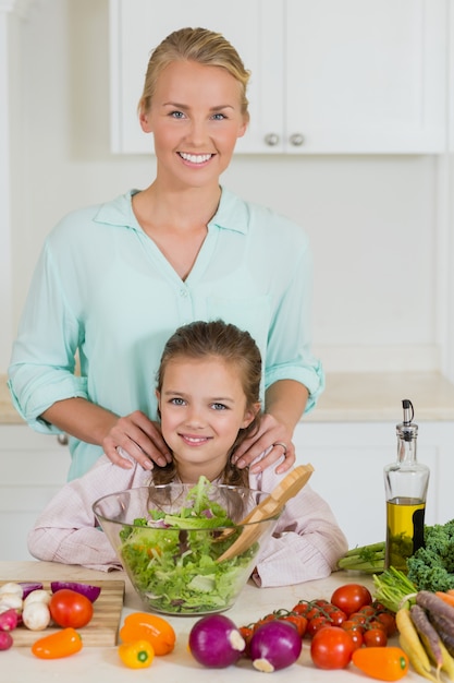 Moeder en dochter die salade in keuken thuis voorbereiden