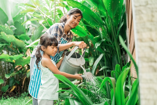 Moeder en dochter die samen haar tuin water geven