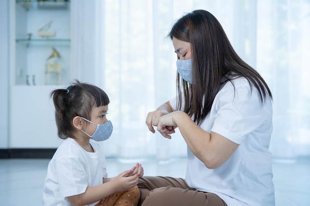 Moeder en dochter die sanitizer handgelreinigers gebruiken voor antibacteriële middelen voorkomen het covid19-virus