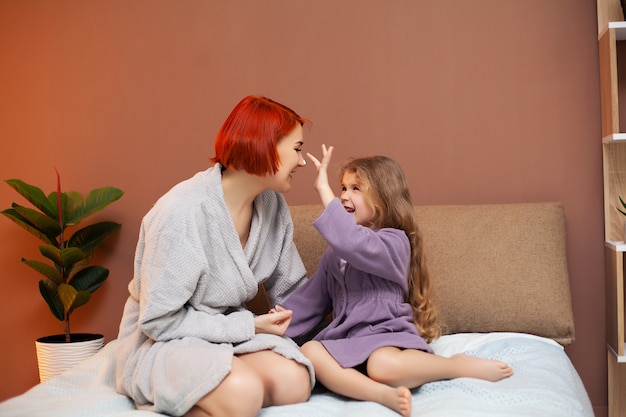 Moeder en dochter doen spa-behandelingen thuis in bed