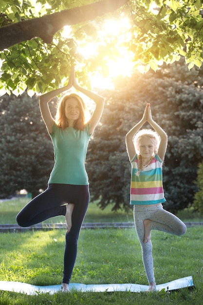 moeder en dochter doen yoga in het park