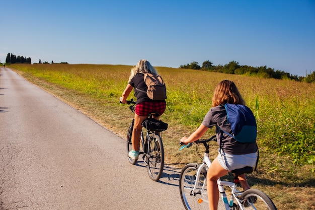 Moeder en dochter fietsers rijden op het platteland