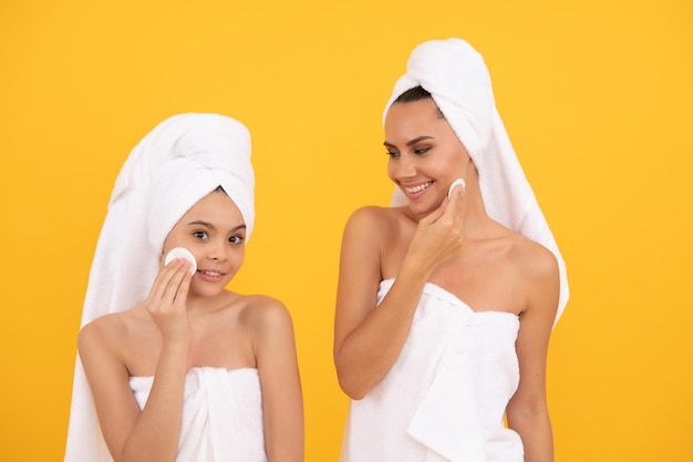 Moeder en dochter gebruiken wattenschijfjes om het gezicht van de make-up schoon te maken met een schoonheidsdag in de spa, schoonheidsbehandeling.