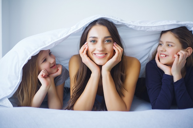 Moeder en dochter genieten thuis in bed