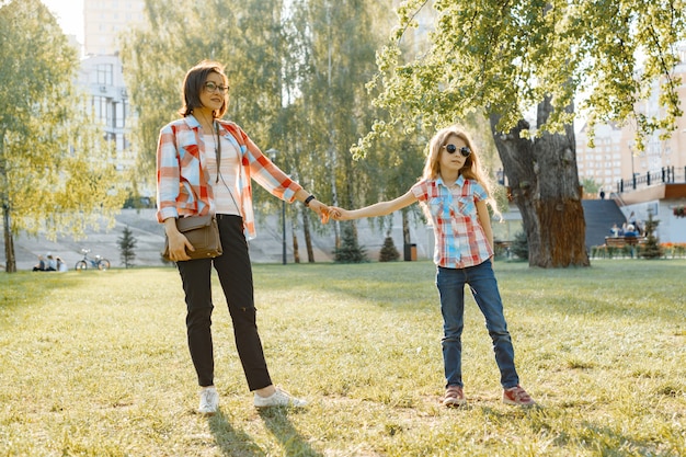 Moeder en dochter hand in hand wandelen in het park