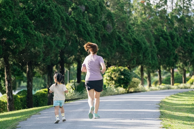 Moeder en dochter hardlopers joggen in het park avond familieactiviteiten moeder en zoon in sportkleding rennen en hebben plezier