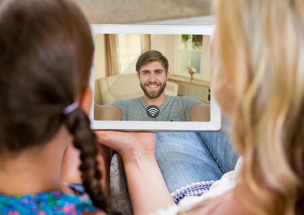 Moeder en dochter hebben een videogesprek met vader in digitale tablet