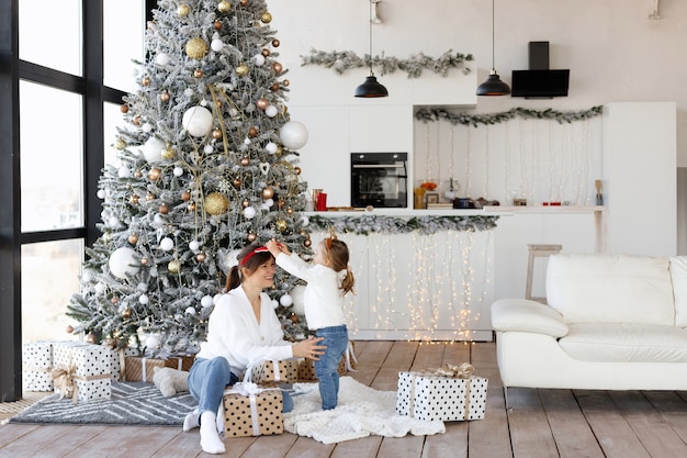 Moeder en dochter hebben plezier naast de kerstboom