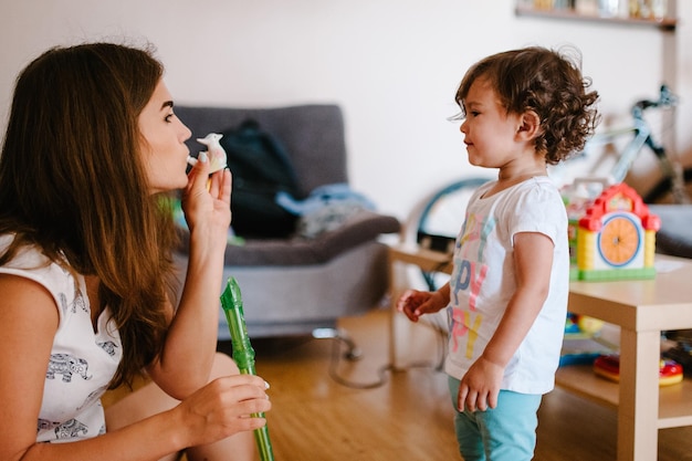 Moeder en dochter houden speelgoed spelen in het spel in de kamer binnen in huis Gelukkig familieportret moeder en meisje concept van een vakantie met het gezin Close-up Emoties van geluk