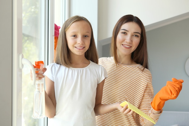 Moeder en dochter in een goed humeur maken het huis schoon