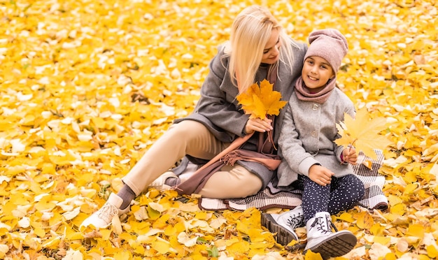 Moeder en dochter in herfst geel park.