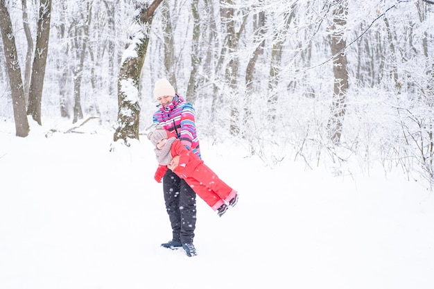 Moeder en dochter in kleurrijke kleding die plezier hebben tijdens een winterwandeling in de natuur