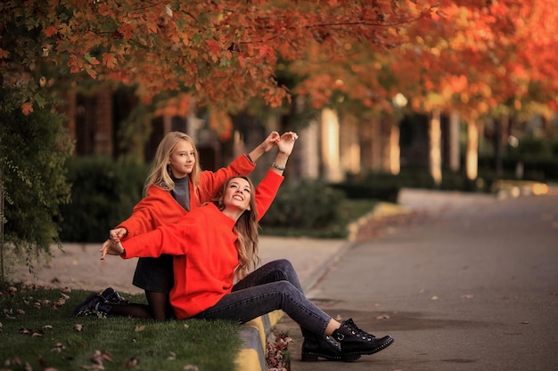 Moeder en dochter in oranje truien hebben plezier tijdens een wandeling in de buurt van landhuizen