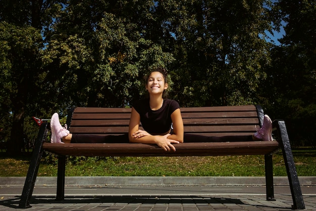 moeder en dochter in sportkleding op een zonnige zomerdag aan de kade in het park aan het fitnessen