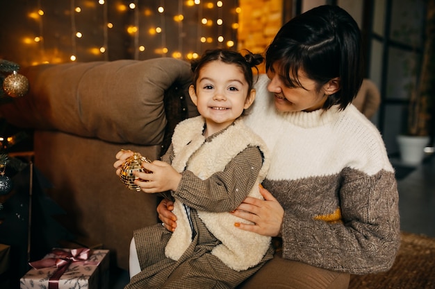 Moeder en dochter kerstboom thuis versieren