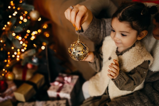 Moeder en dochter kerstboom thuis versieren