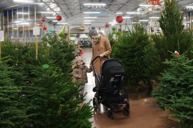 Moeder en dochter kiezen een kerstboom in een winkel