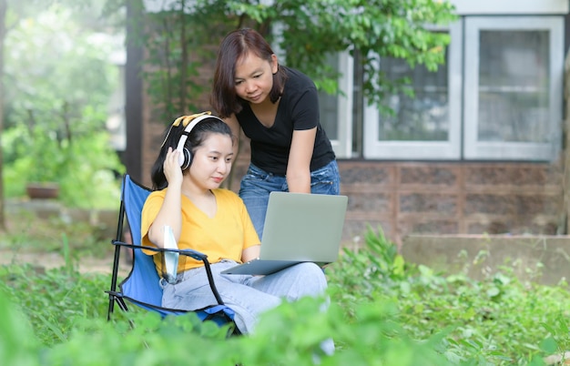 Moeder en dochter kijken naar laptop in de moestuin