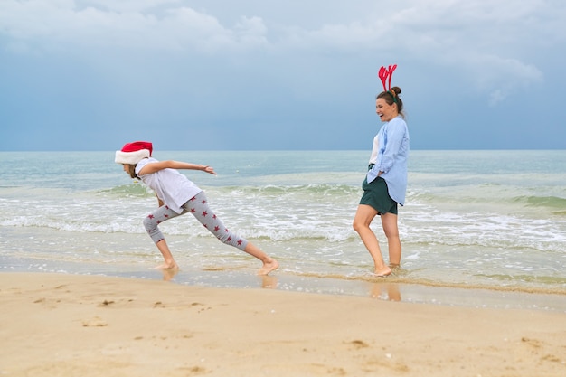 moeder en dochter kind plezier vieren kerst op een strand