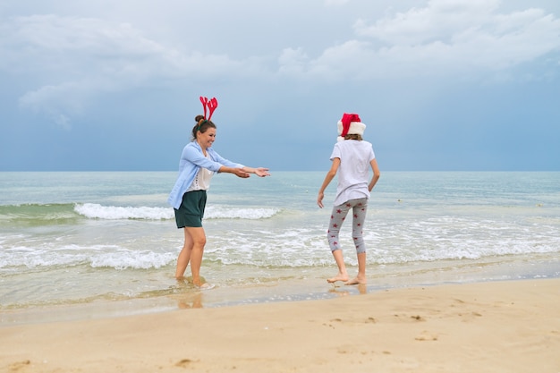 moeder en dochter kind plezier vieren kerst op een strand