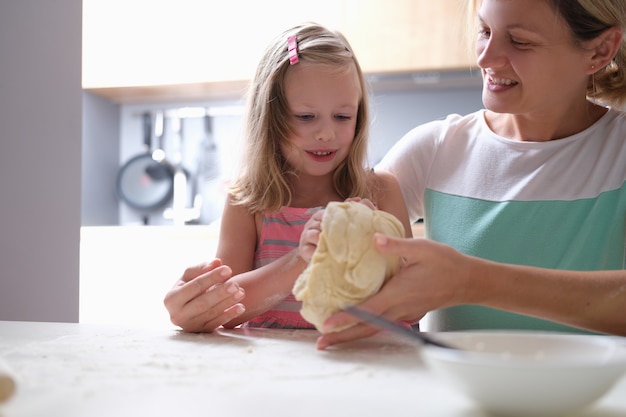 Moeder en dochter kneden deeg samen close-up